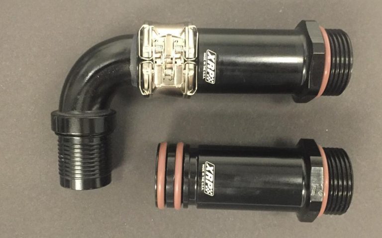 2 inch extended -16 male ORB to clamshell fitting designed for use on oil pans on Top Fuel and Funny Cars to extend the suction supply hose outside of the lower engine ballistic restraint flak blanket. Allows blanket to fit tight to the block and pan. Shown with clamshell in super nickel finish if you want something other than purple